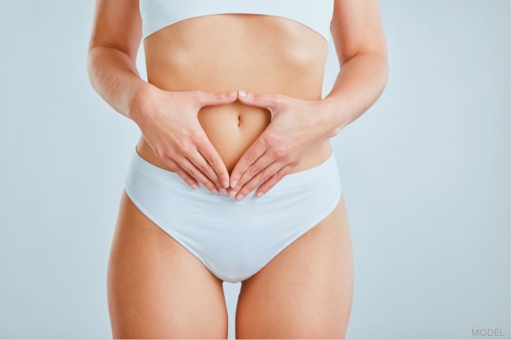 woman with her hands on their stomach (MODEL)
