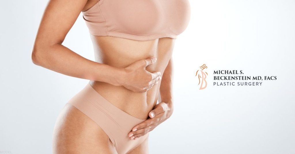 A person with their hands on their stomach (model) Michael S. Beckenstein, MD Logo.