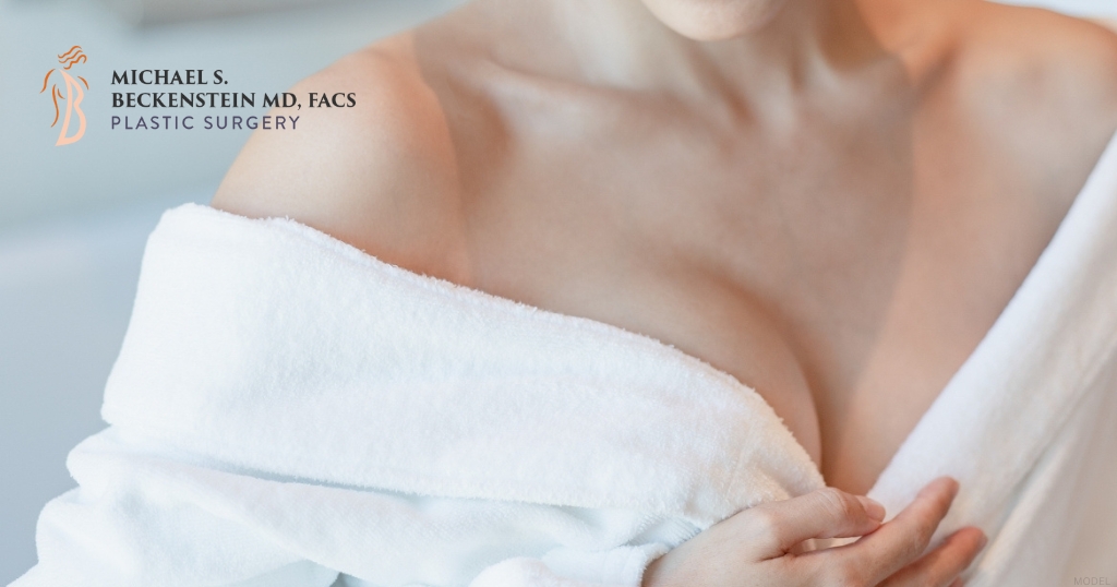 Woman in a white robe with focus on chest area (model) Michael S. Beckenstein, MD Logo